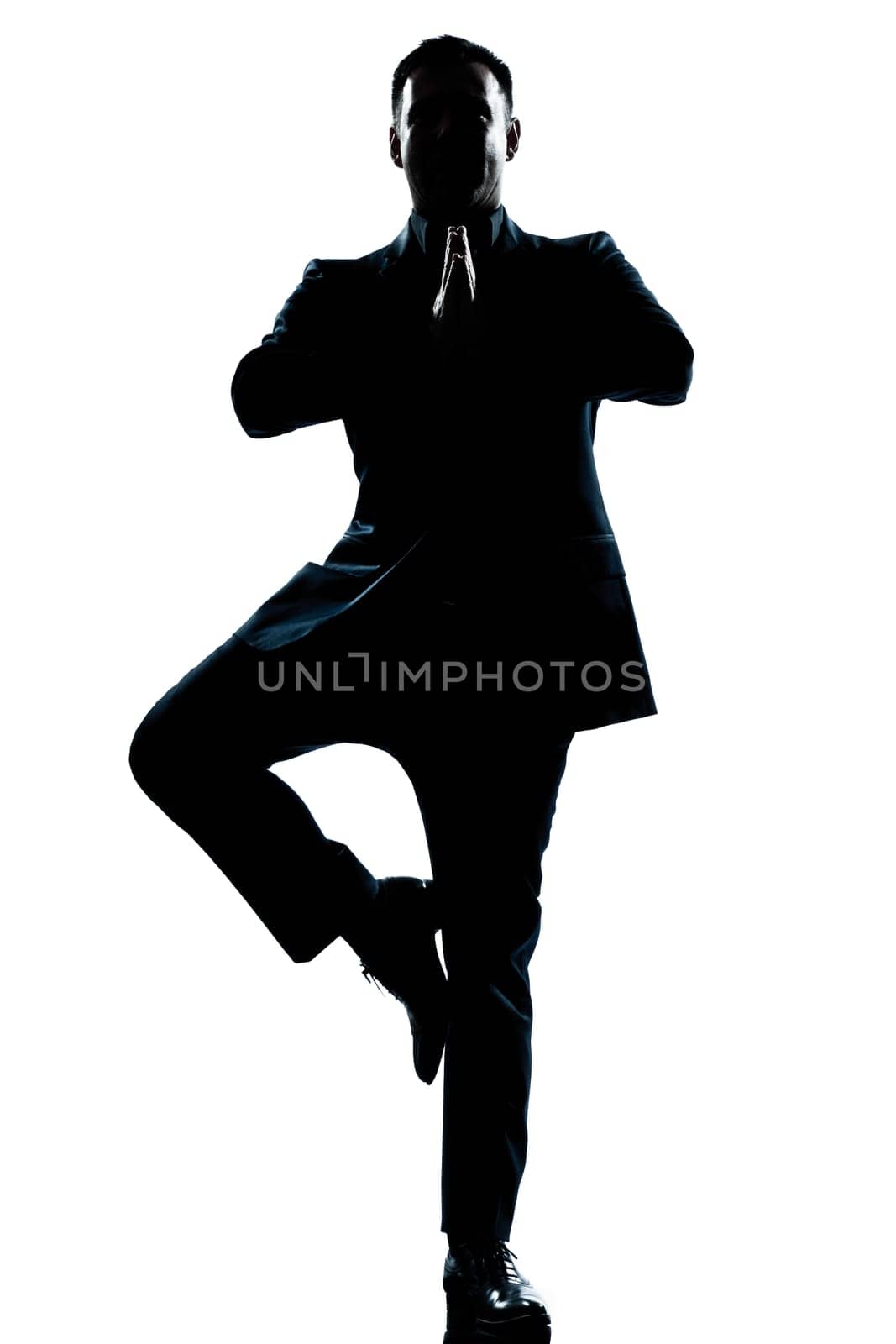 one caucasian business man yoga tree pose  full length silhouette in studio isolated white background