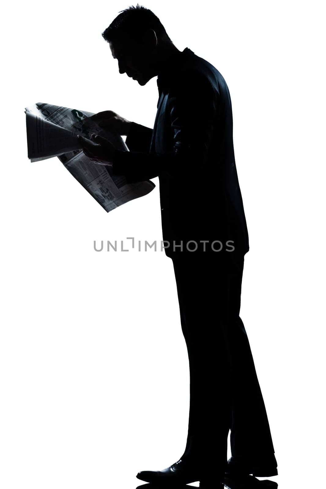 one caucasian man walking reading newspaper  full length silhouette in studio isolated white background