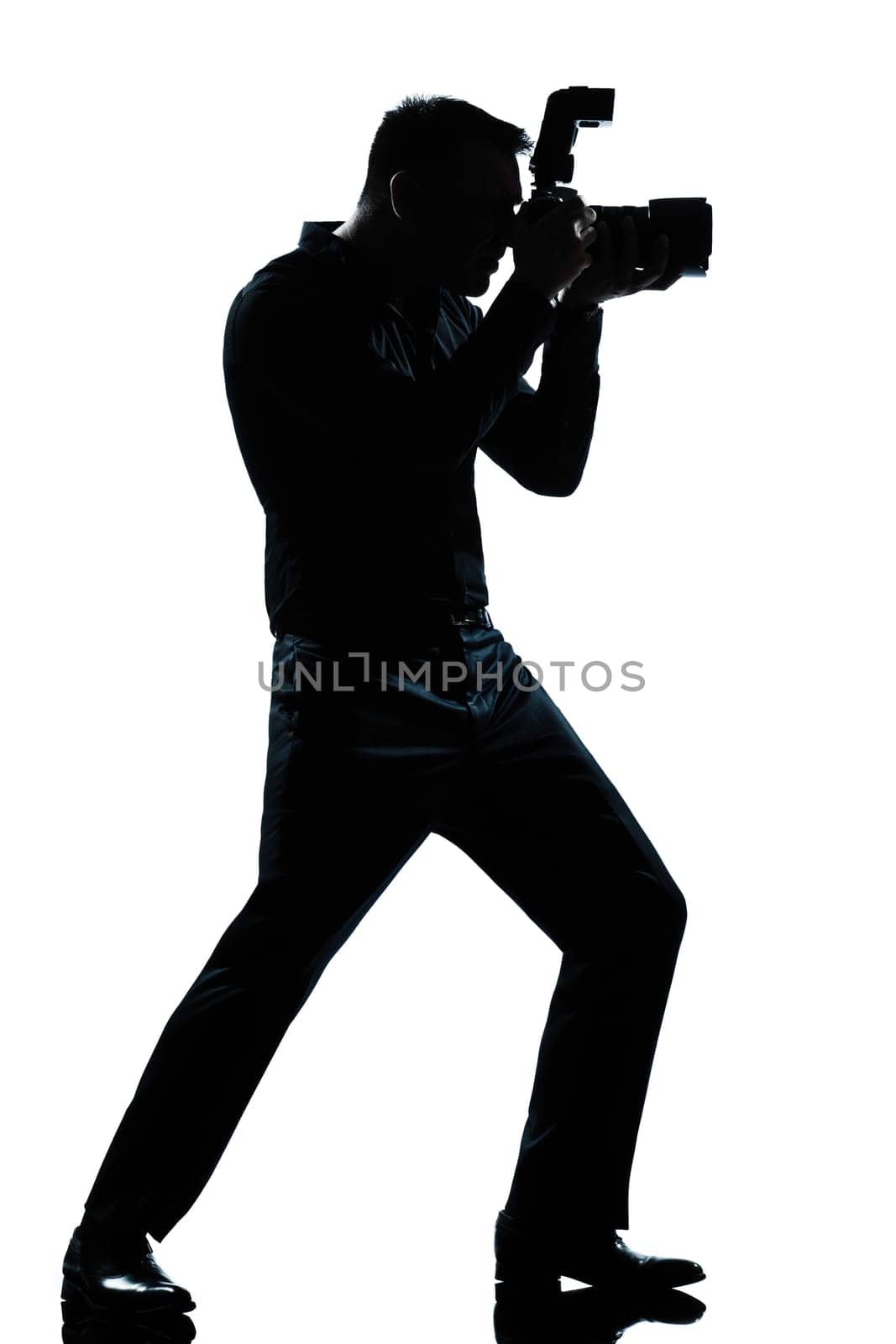 one caucasian man photographer full length silhouette in studio isolated white background