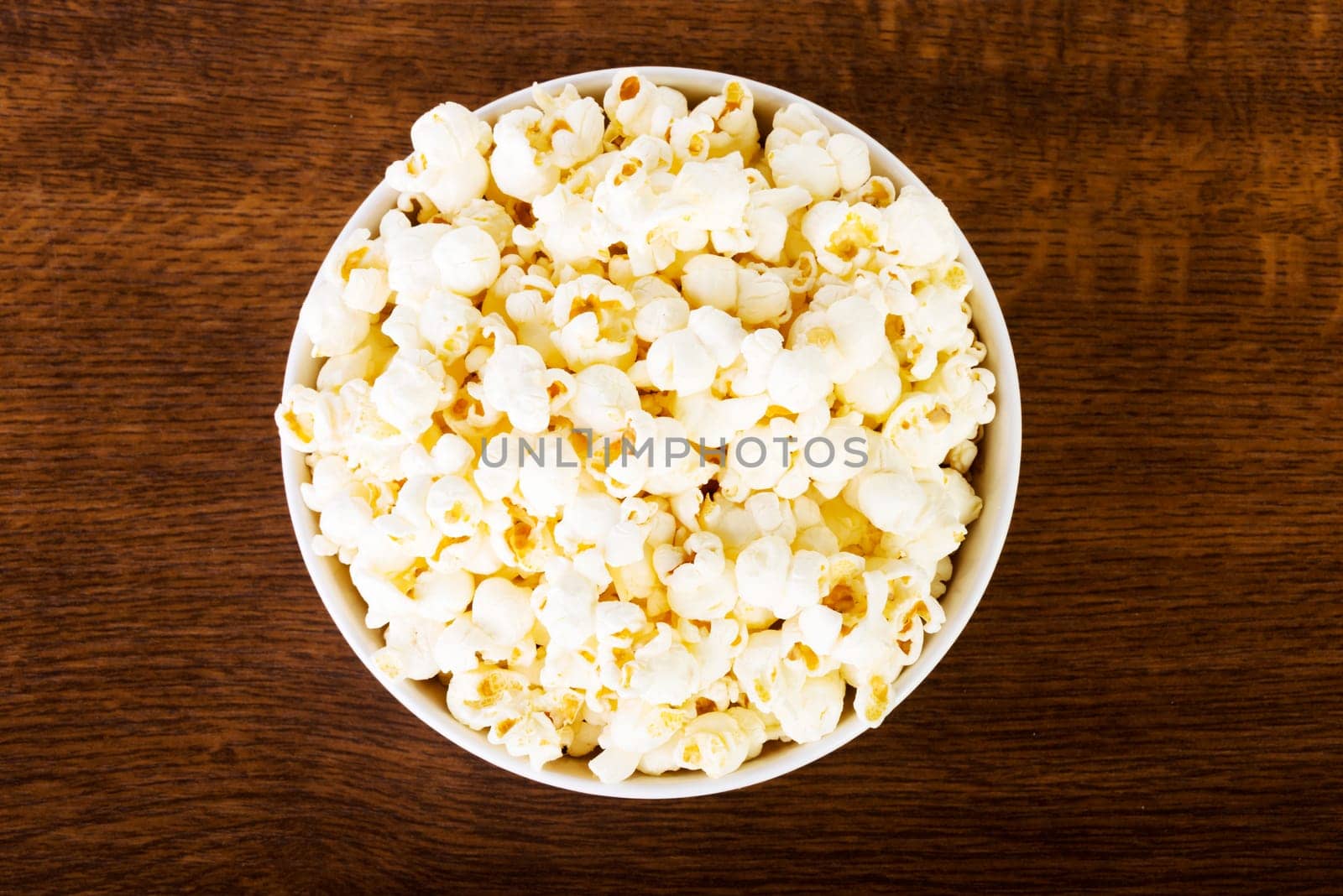 Popcorn in bowl on wooden table