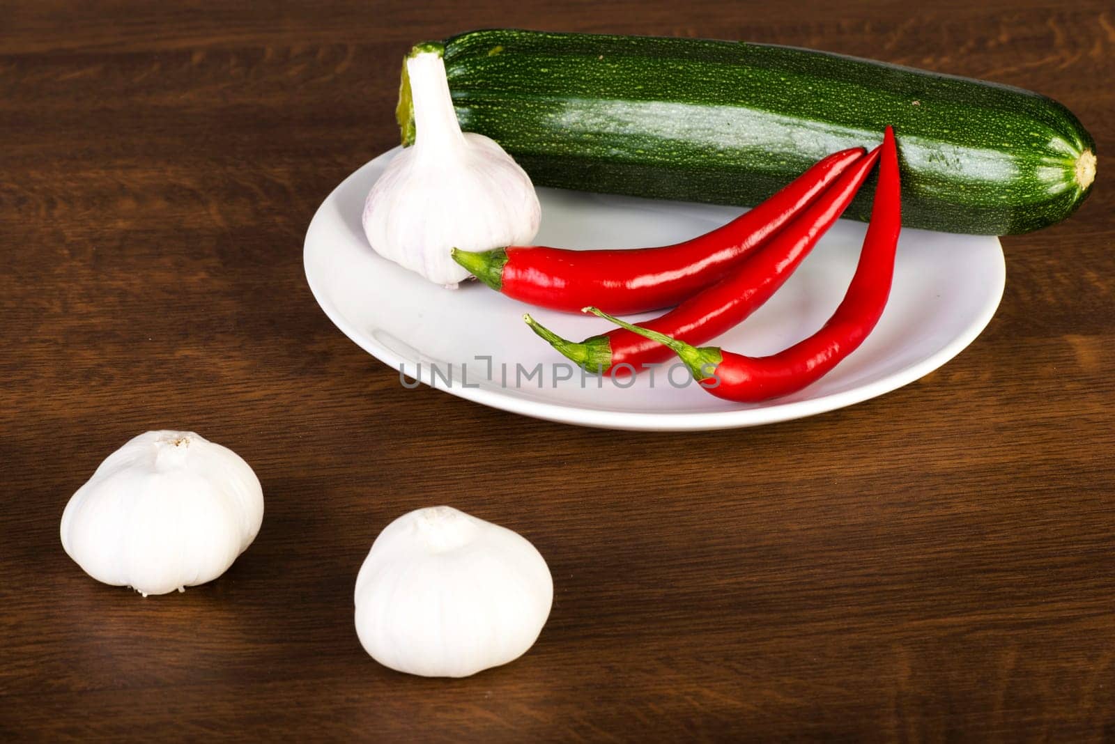 Zucchini, garlik and red hot chilie peppers on kitchen table