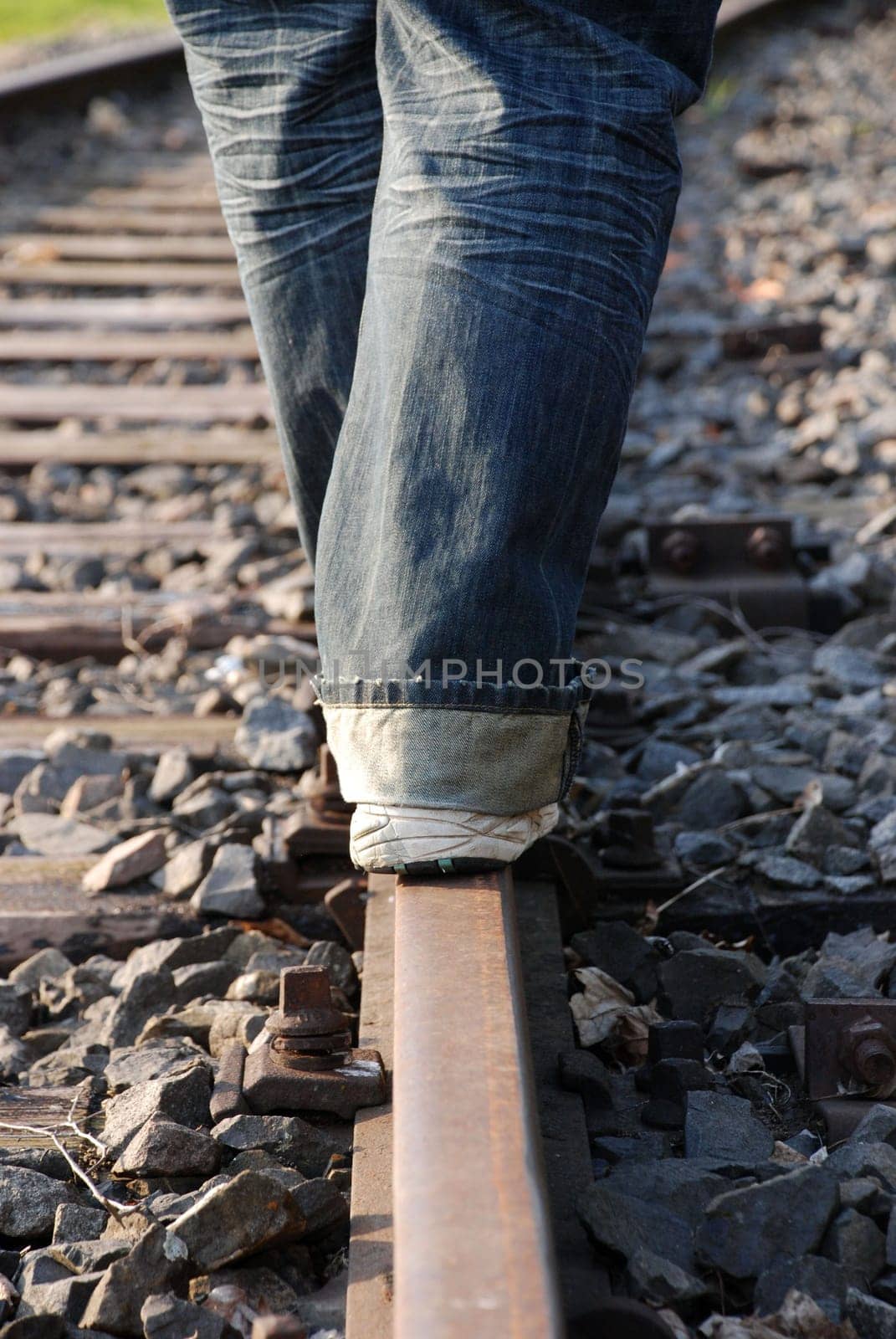 a person balancing on a railway track, danger