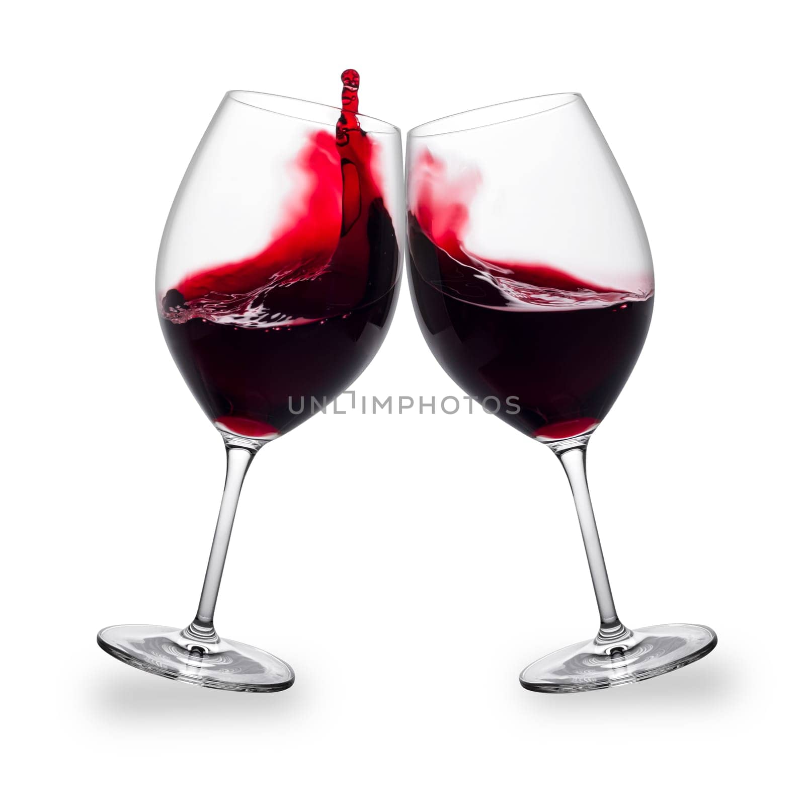 Two red wine glasses toasting