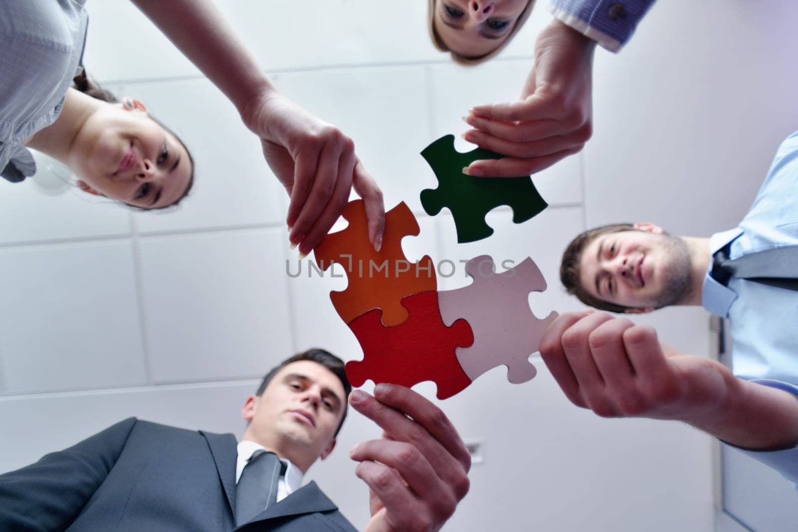 Group of business people assembling jigsaw puzzle and represent team support and help concept