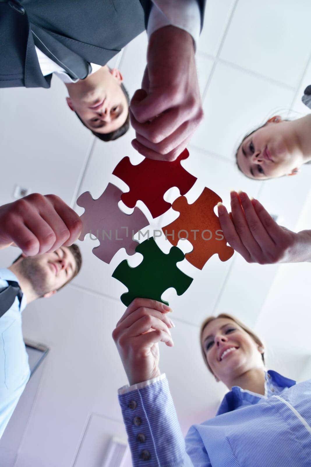 Group of business people assembling jigsaw puzzle and represent team support and help concept