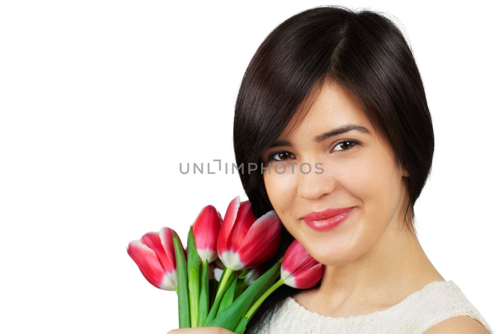 Beautiful young woman smelling a bunch of fresh red tulips