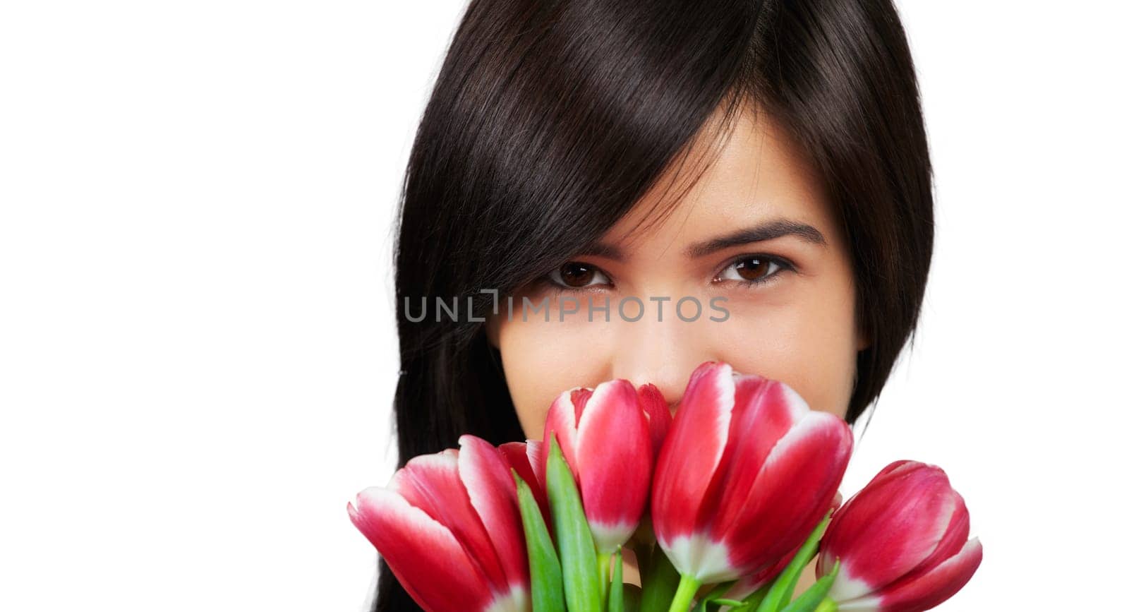 Beautiful young woman smelling a bunch of fresh red tulips