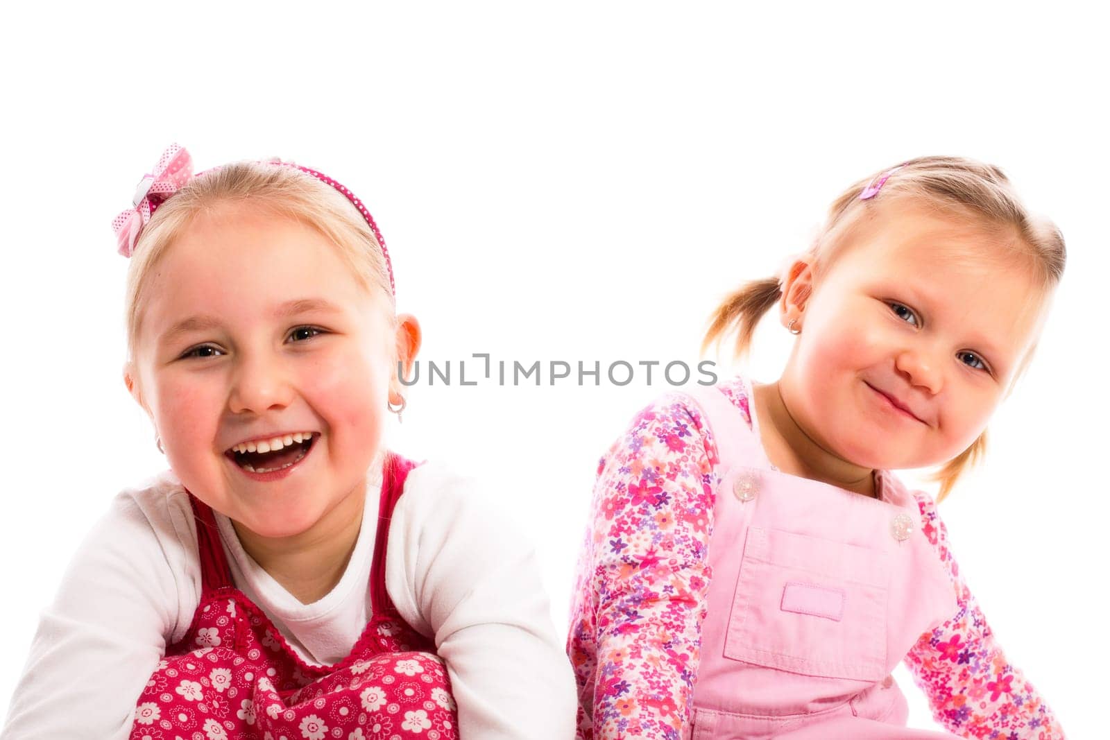 studio shot of two laughing sisters