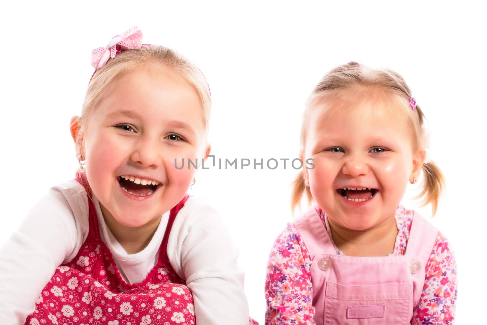 studio shot of two laughing sisters