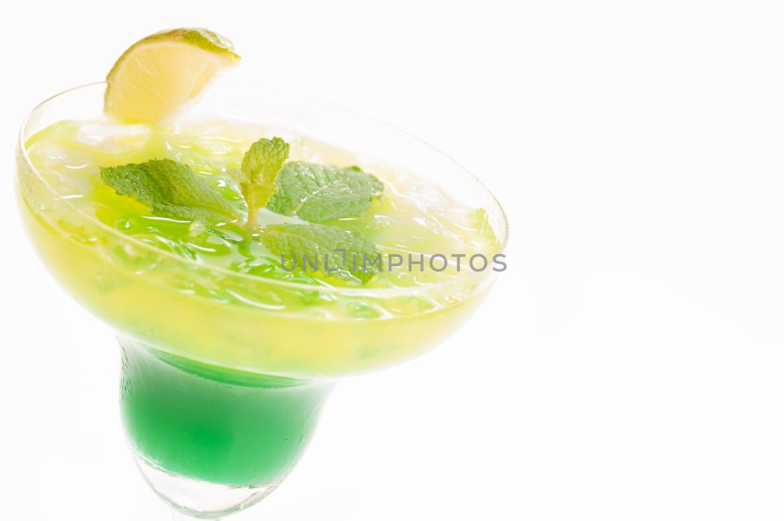 Citrus Paradise Cocktail made from Midori Melon, White Rum, pineapple, lime juice and garnishes with lime slice and fresh mints leaves