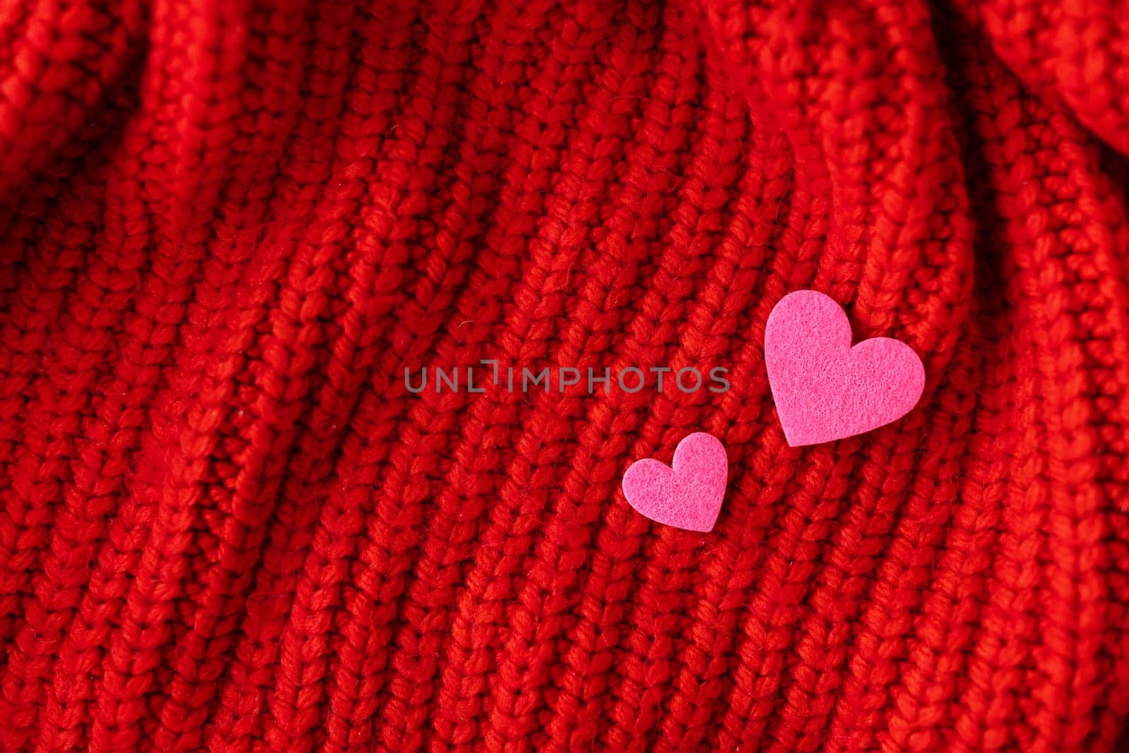 Decorative pink heart on a red knitted background, top view. Place for an inscription