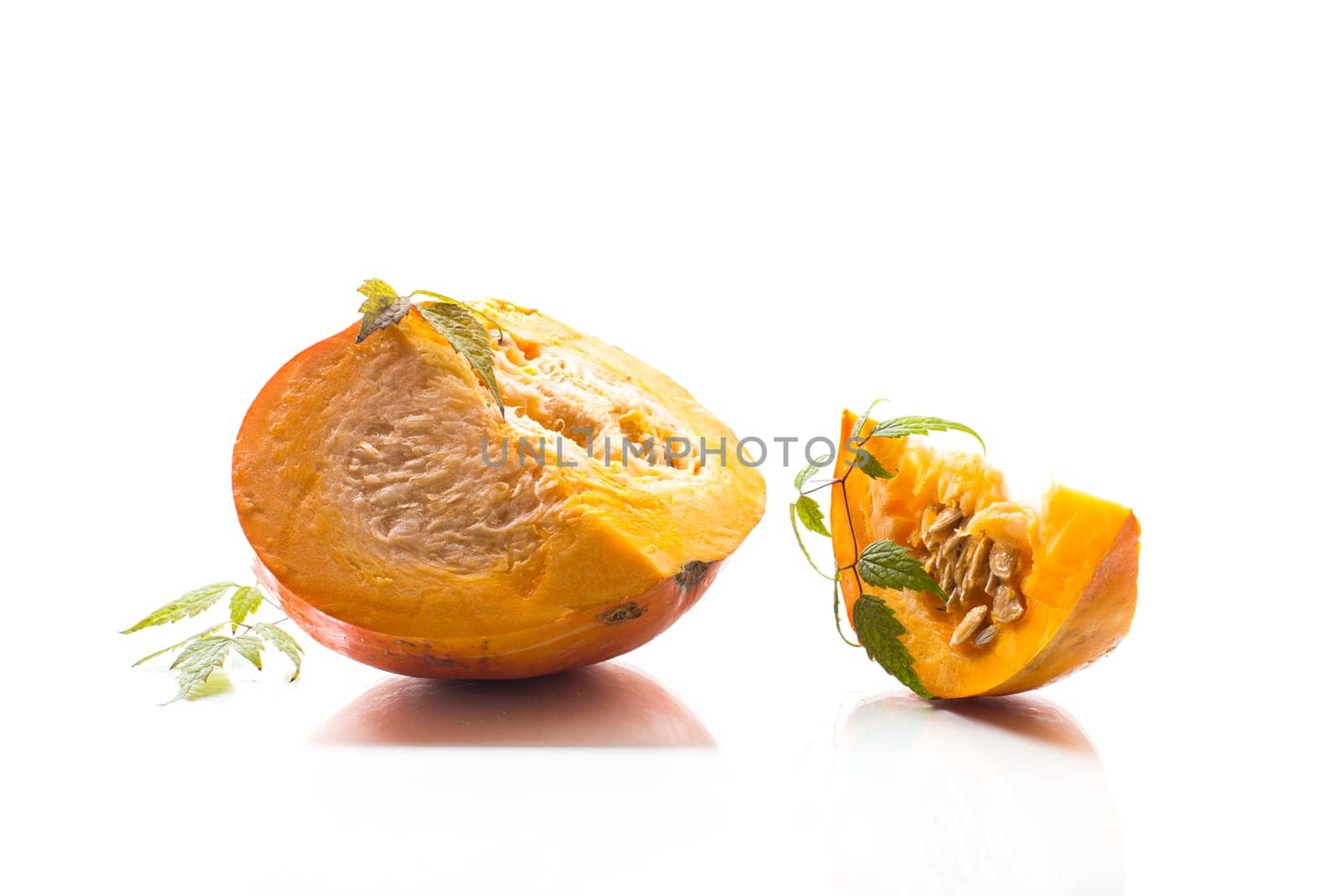 A piece of ripe orange pumpkin with seeds isolated on a white background.