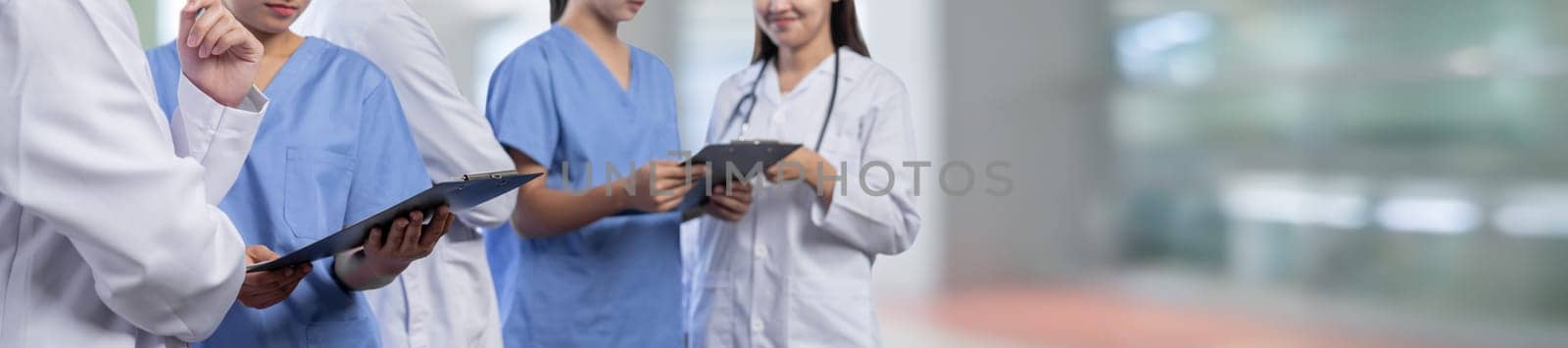Medical staff team with doctor nurse and specialist working together with laptop and tablet on blur hospital corridor background. Medical and healthcare community in panoramic banner. Neoteric