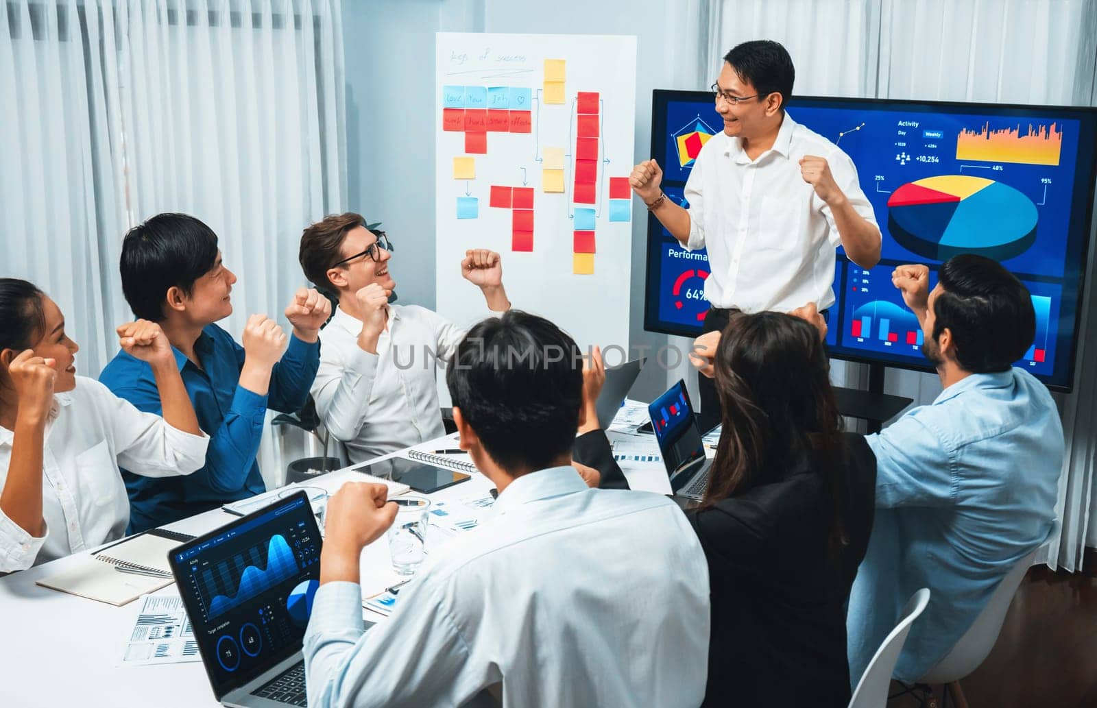 Analyst team leader celebrate with his colleague after successful data analysis meeting using FIntech software power with business intelligence or BI dashboard. Prudent