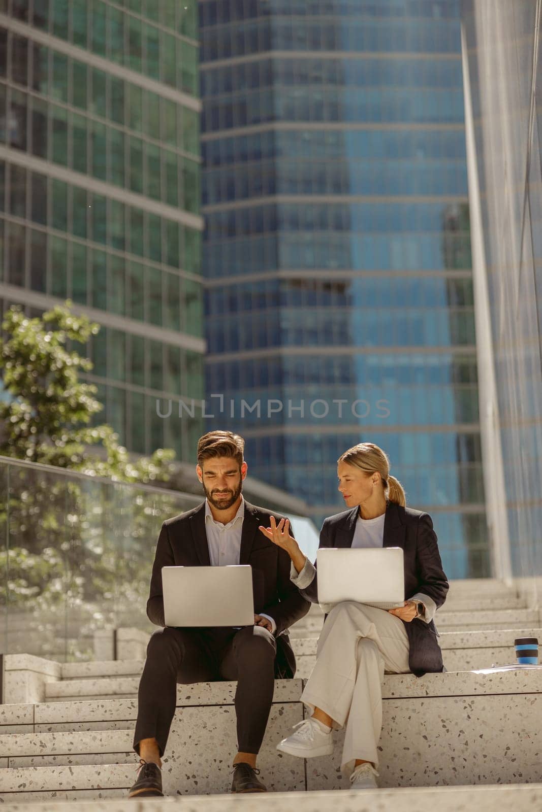 Focused businessman and businesswomen working outdoor on laptop with new startup project