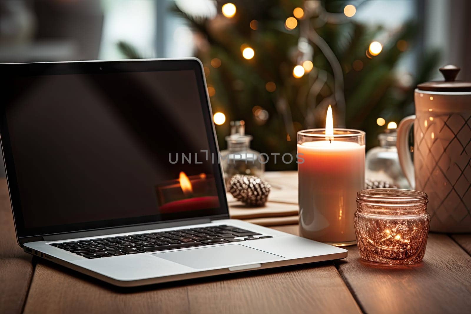 a laptop computer on a wooden table with candles and christmas lights in the window behind it is a lit candle
