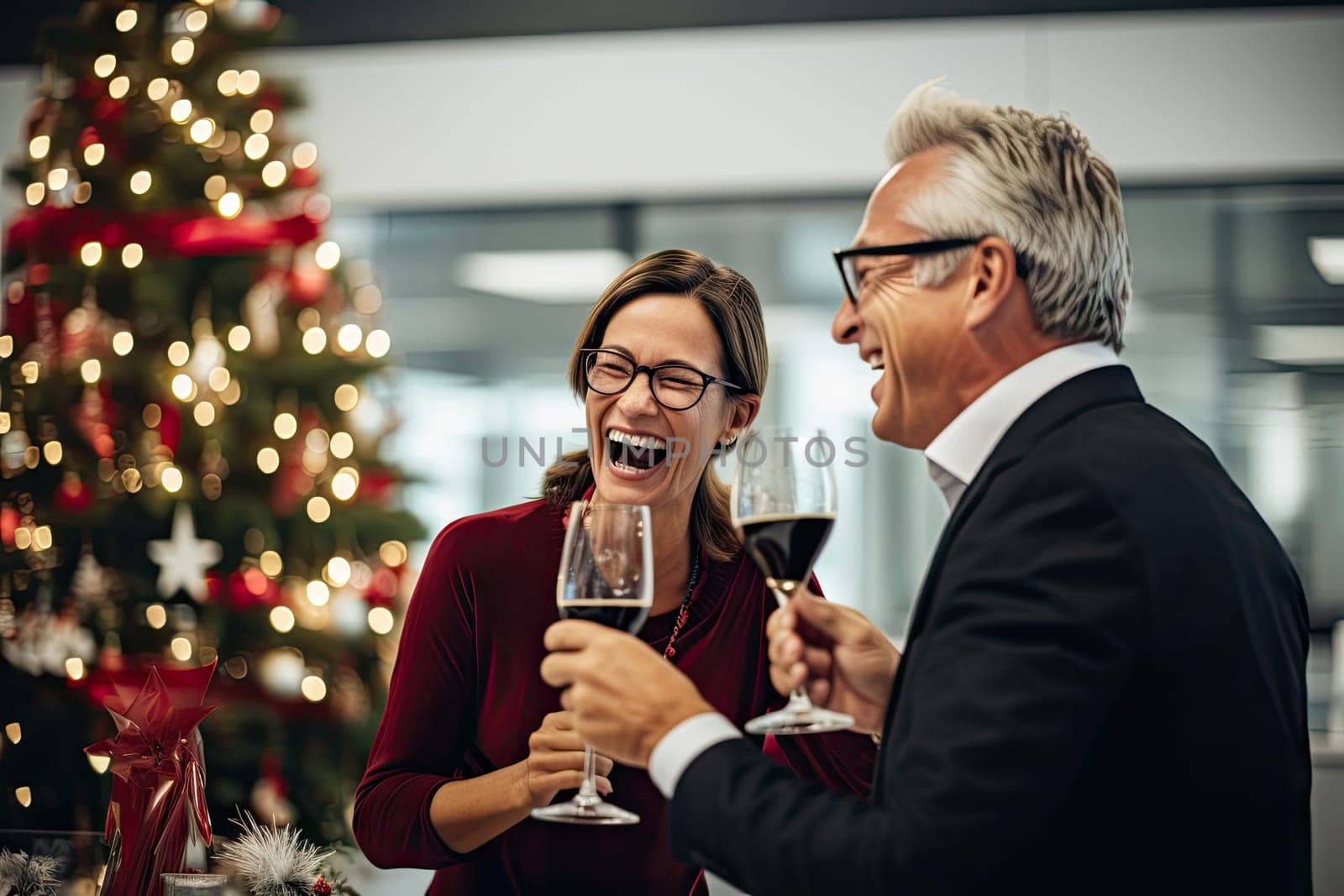 a man and woman drinking wine at a table with a christmas tree in the background that is decorated with lights