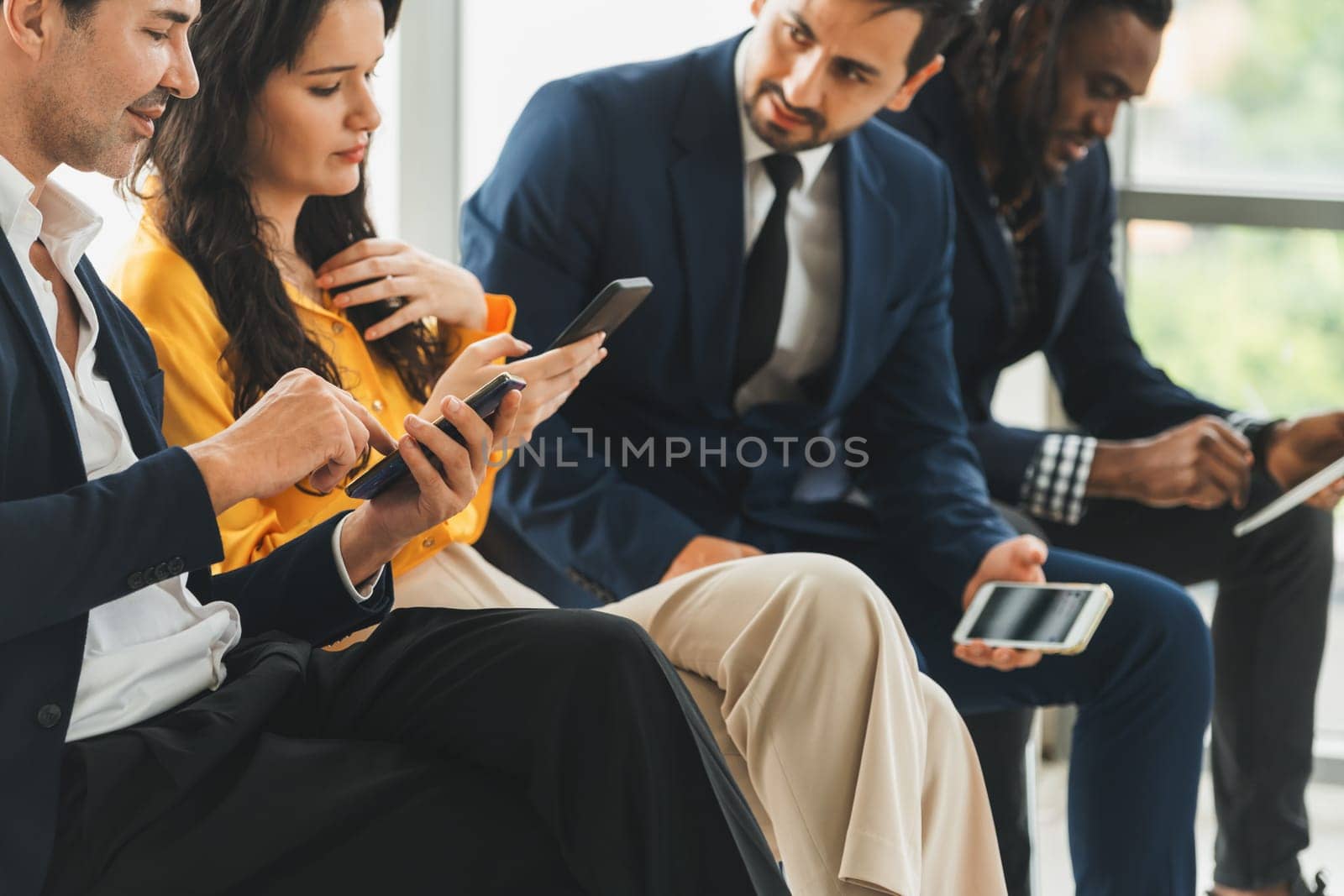 A group of diversity businessman sitting while sharing their data by using smart phone in side view. Smart businesswoman negotiating about finance information with handsome manager. Intellectual.