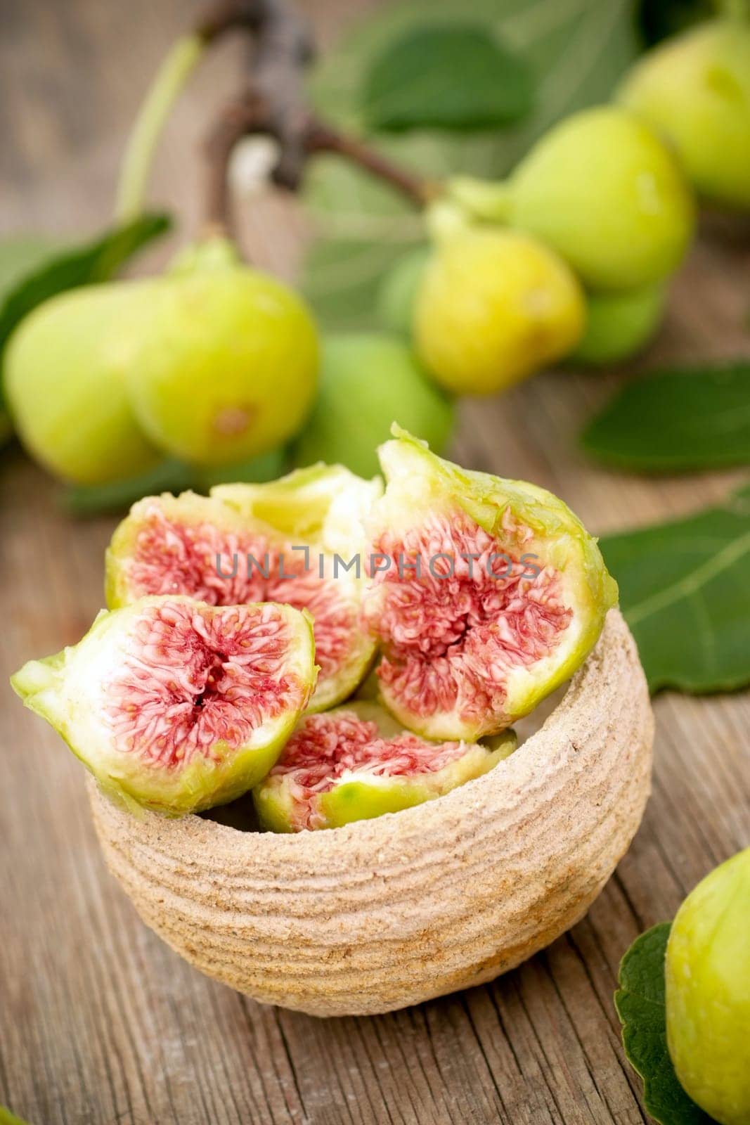 Delicious fresh white figs in bowl on wooden backgroud