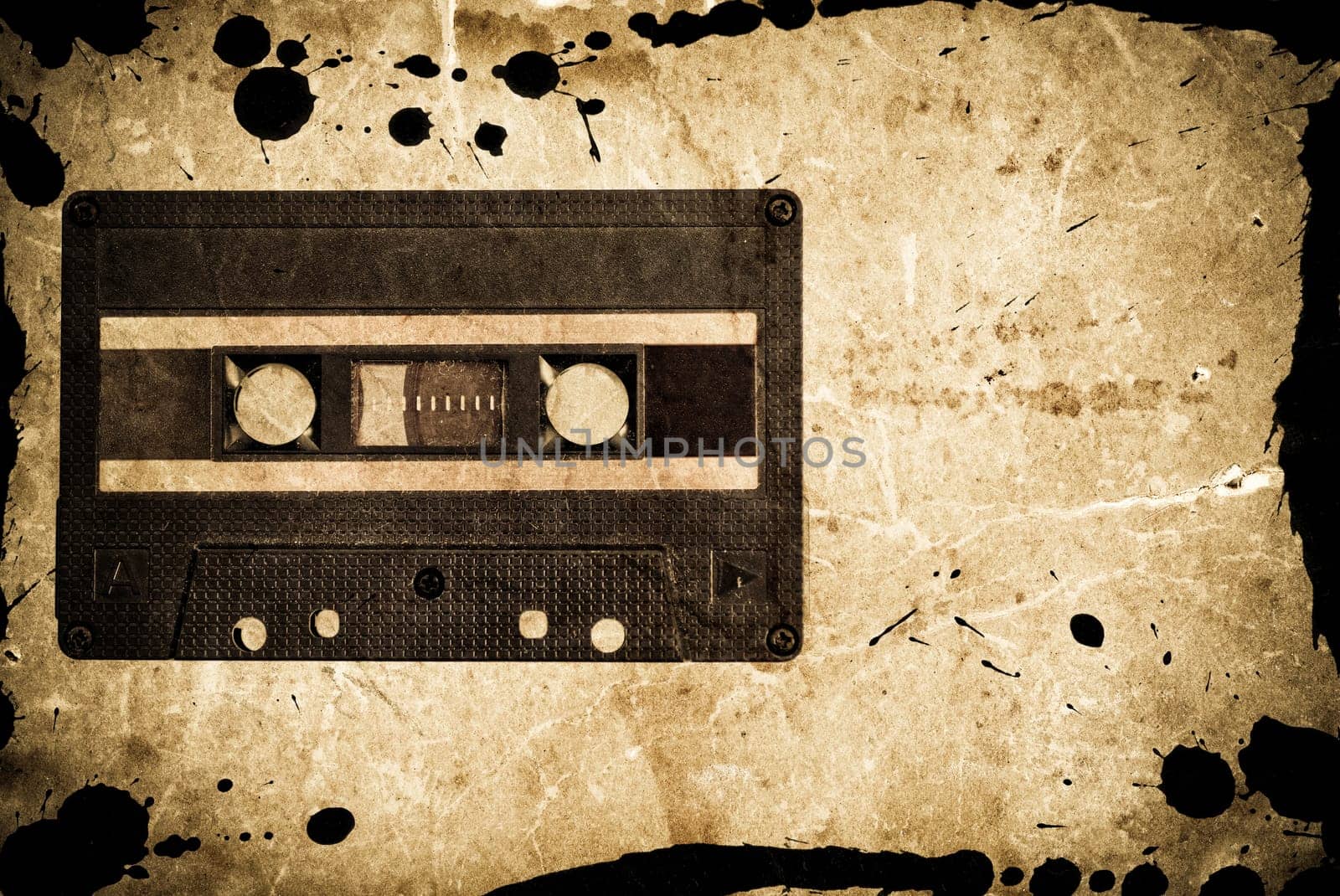 Grungy audio cassette on old paper background