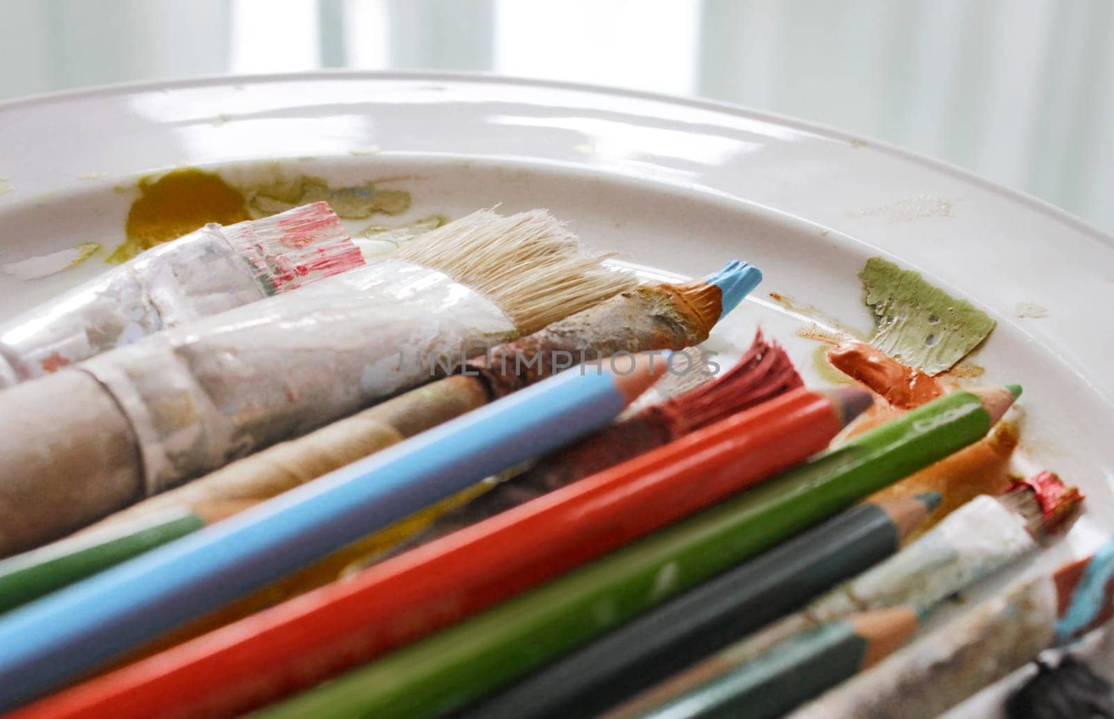 Various brushes and colored pencils in close-up