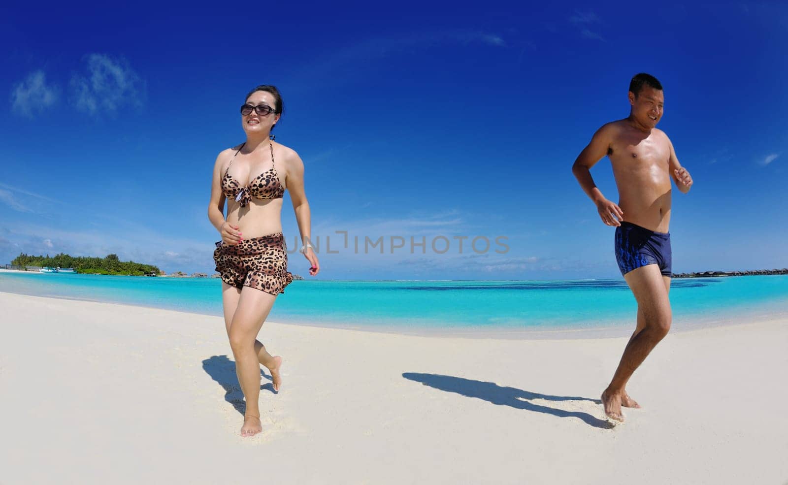 happy young asian couple enjoying summer and have on beautiful white sand beach