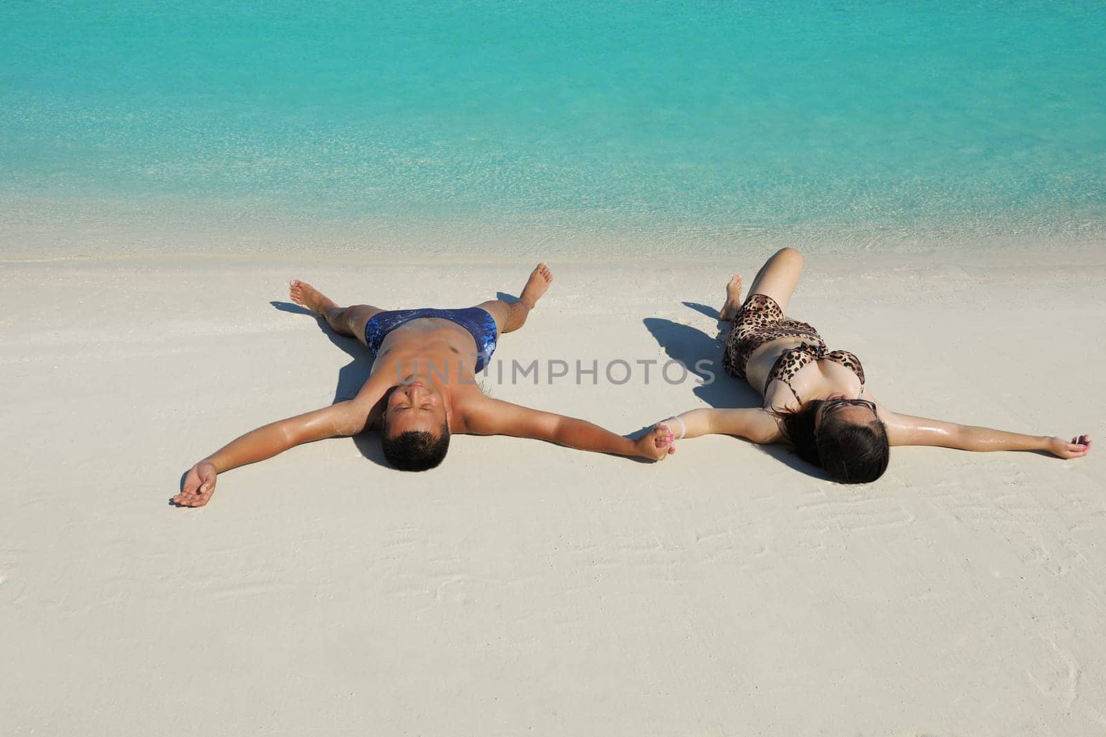 happy young asian couple enjoying summer and have on beautiful white sand beach