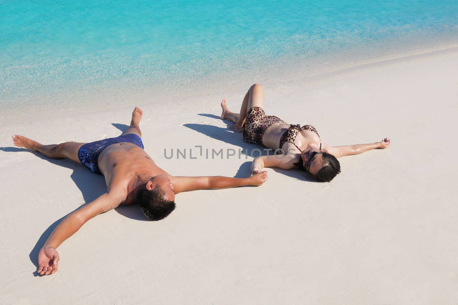 happy young asian couple enjoying summer and have on beautiful white sand beach