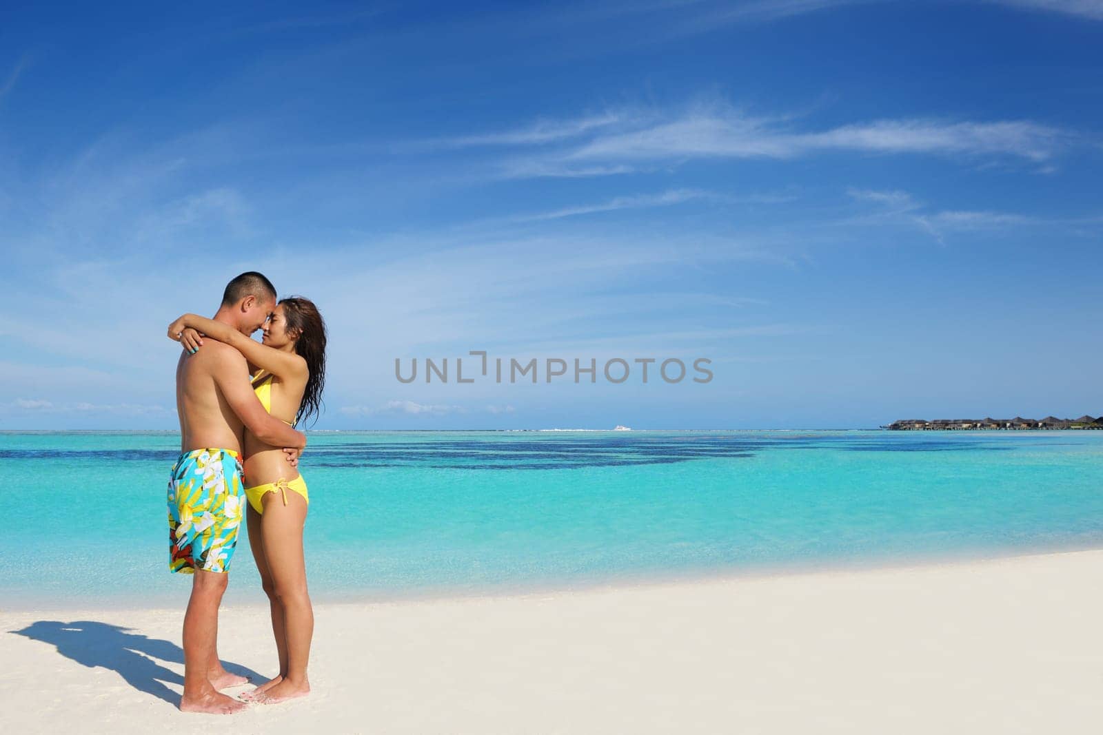 happy young asian couple enjoying summer and have on beautiful white sand beach