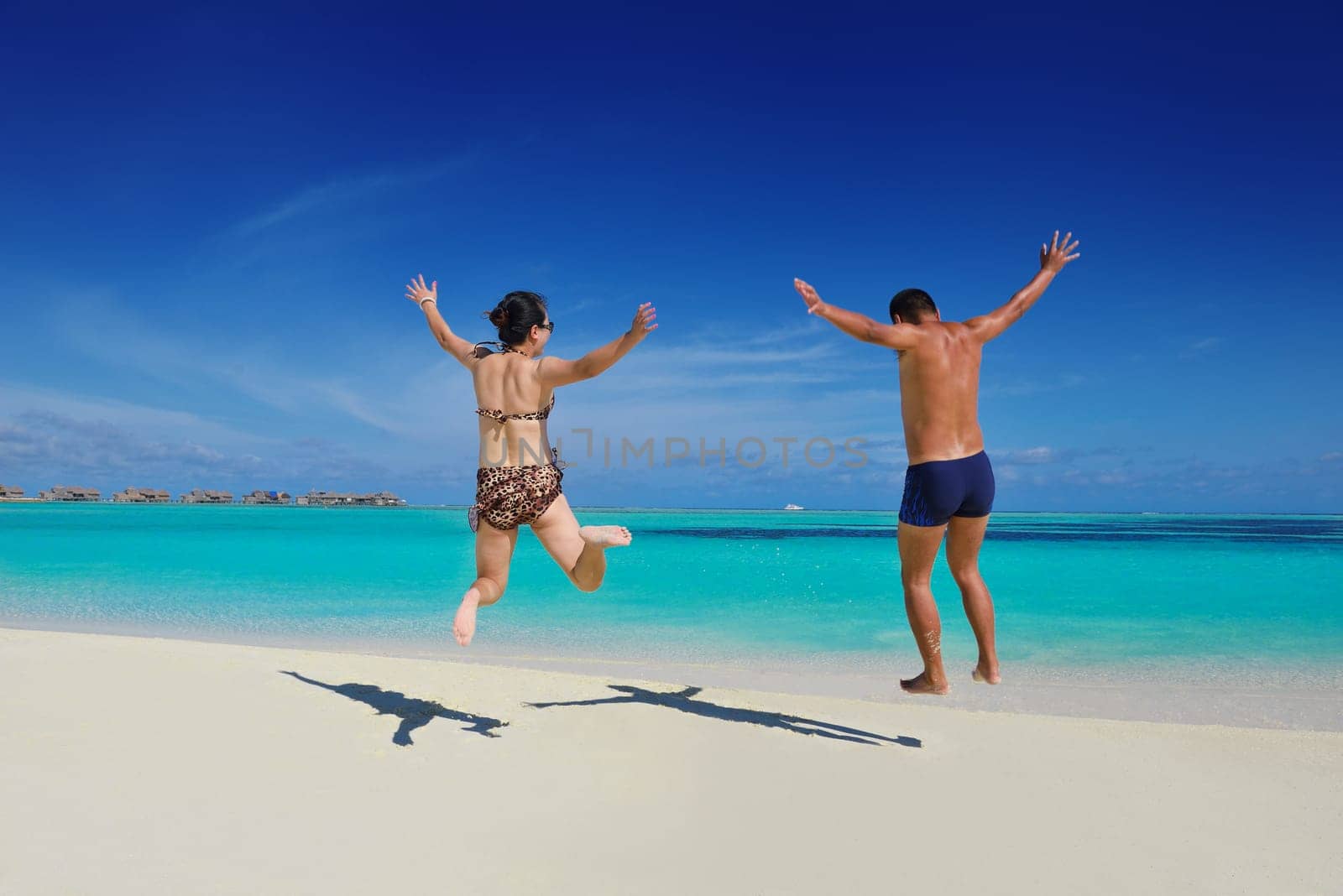 happy young asian couple enjoying summer and have on beautiful white sand beach