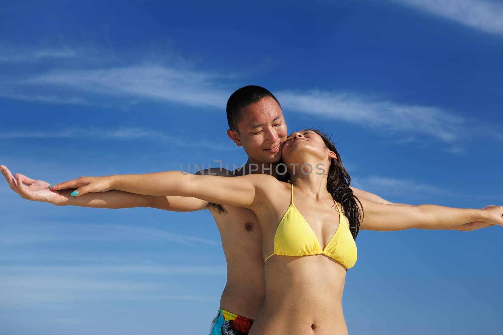 happy young asian couple enjoying summer and have on beautiful white sand beach