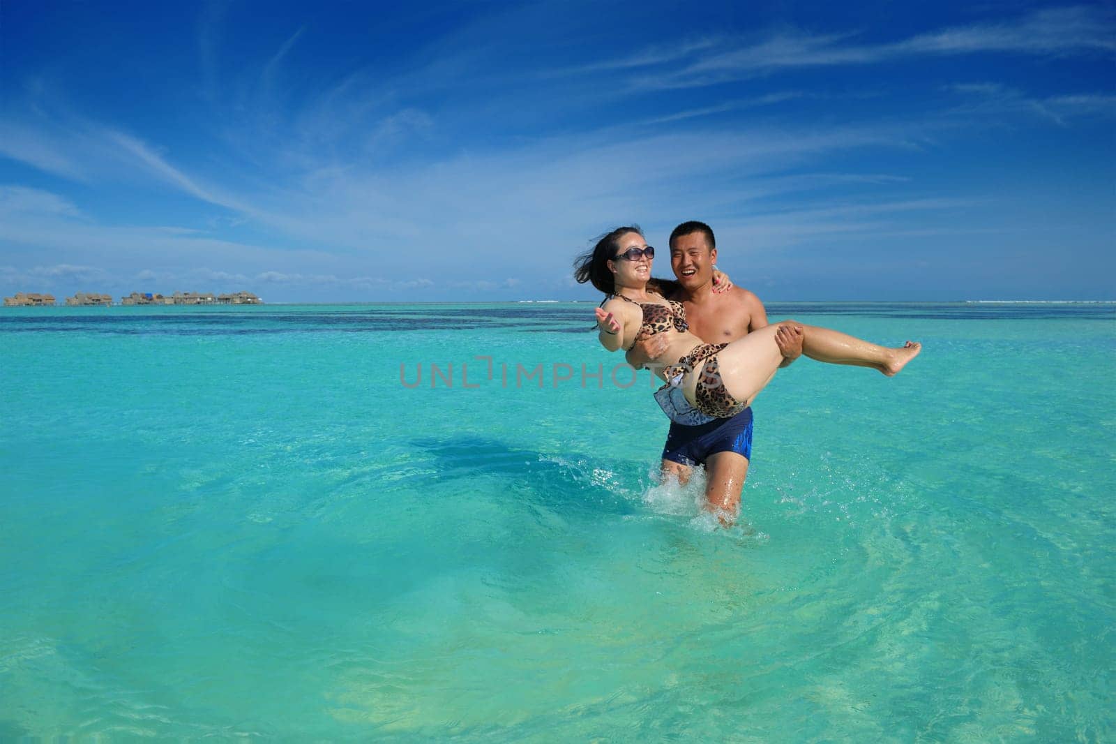 happy young asian couple enjoying summer and have on beautiful white sand beach
