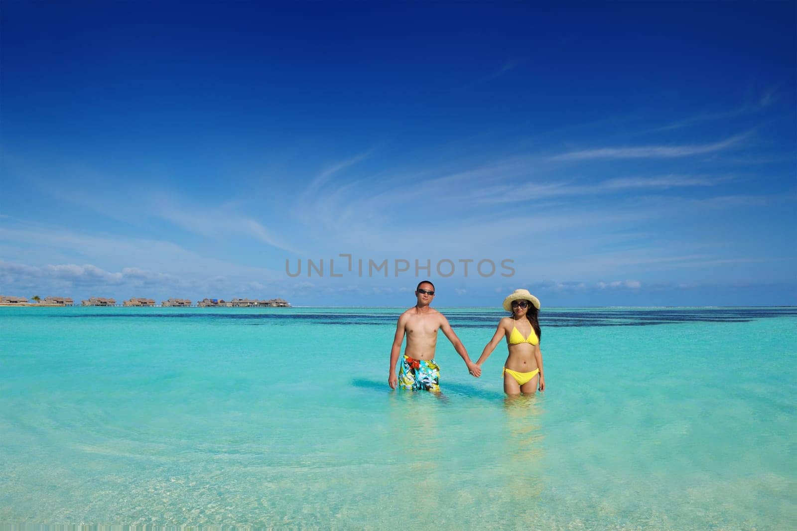 happy young asian couple enjoying summer and have on beautiful white sand beach