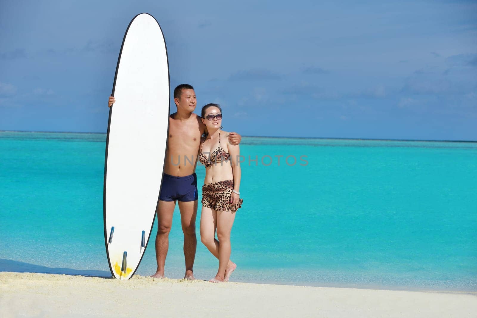happy young asian couple enjoying summer and have on beautiful white sand beach