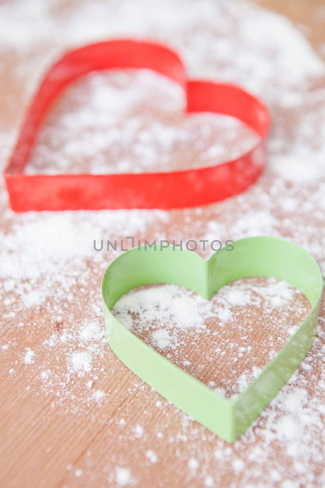 Closeup of heart shaped gingerbread biscuit cutters and dough