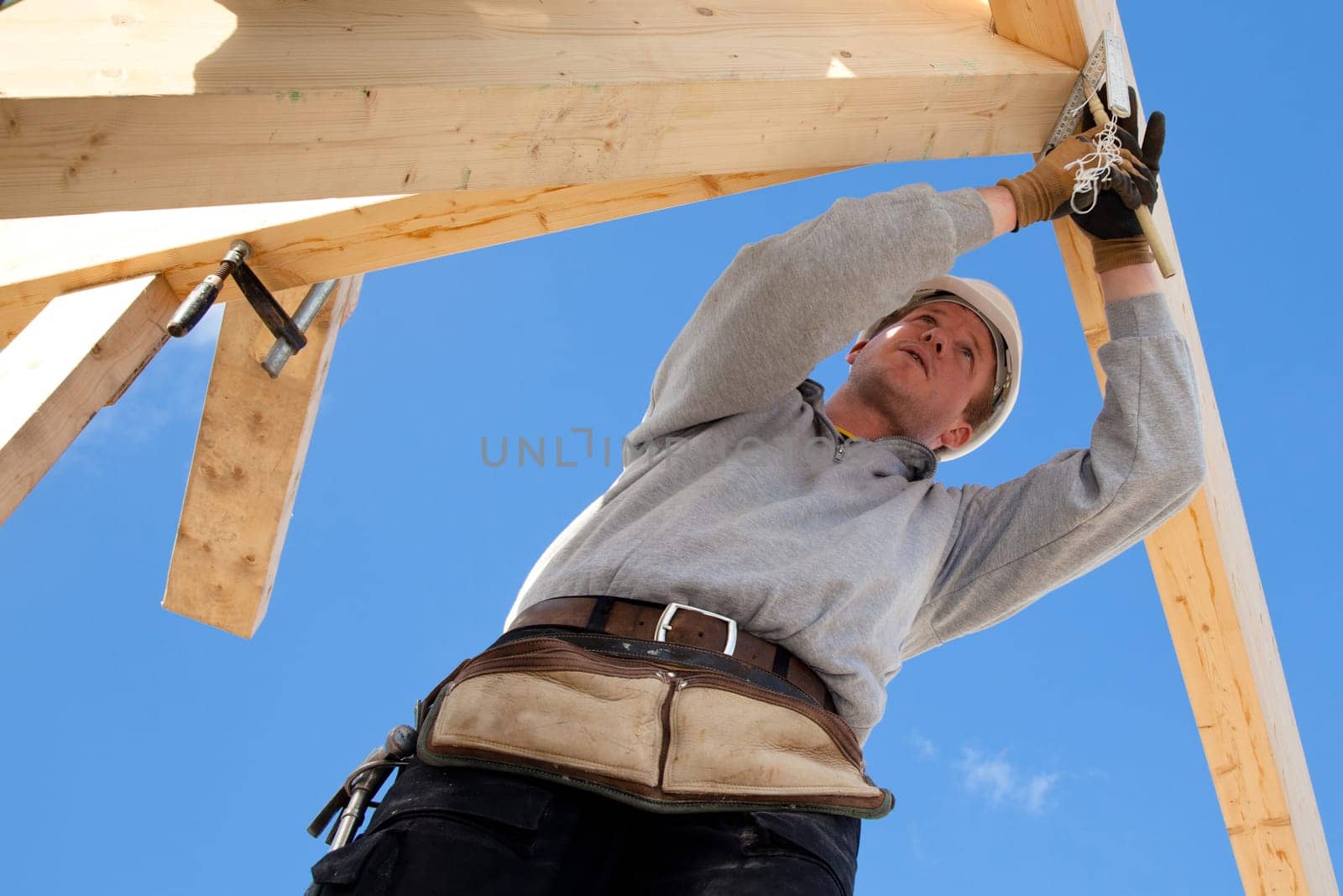 carpenter at work with wooden  roof construction
