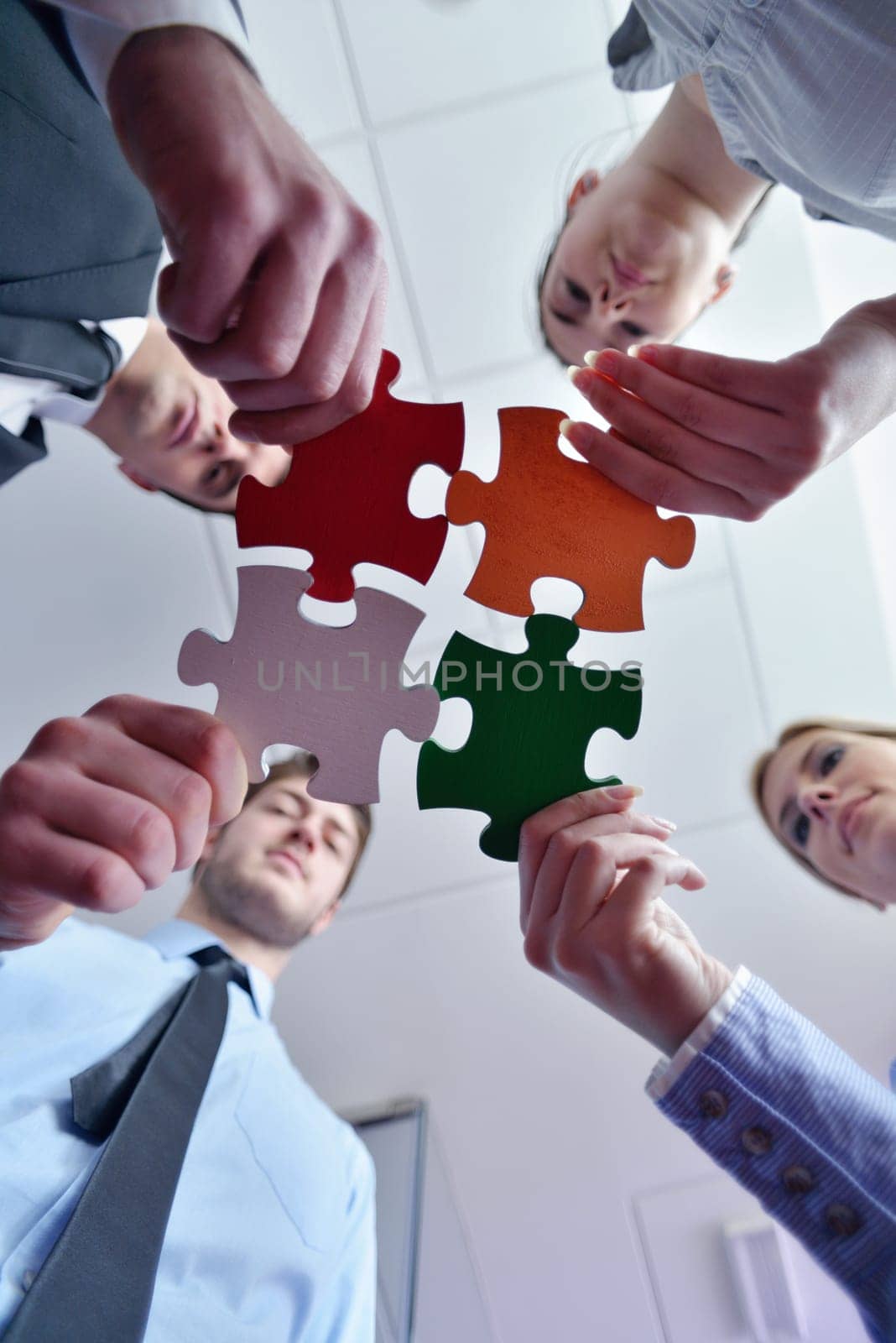 Group of business people assembling jigsaw puzzle and represent team support and help concept
