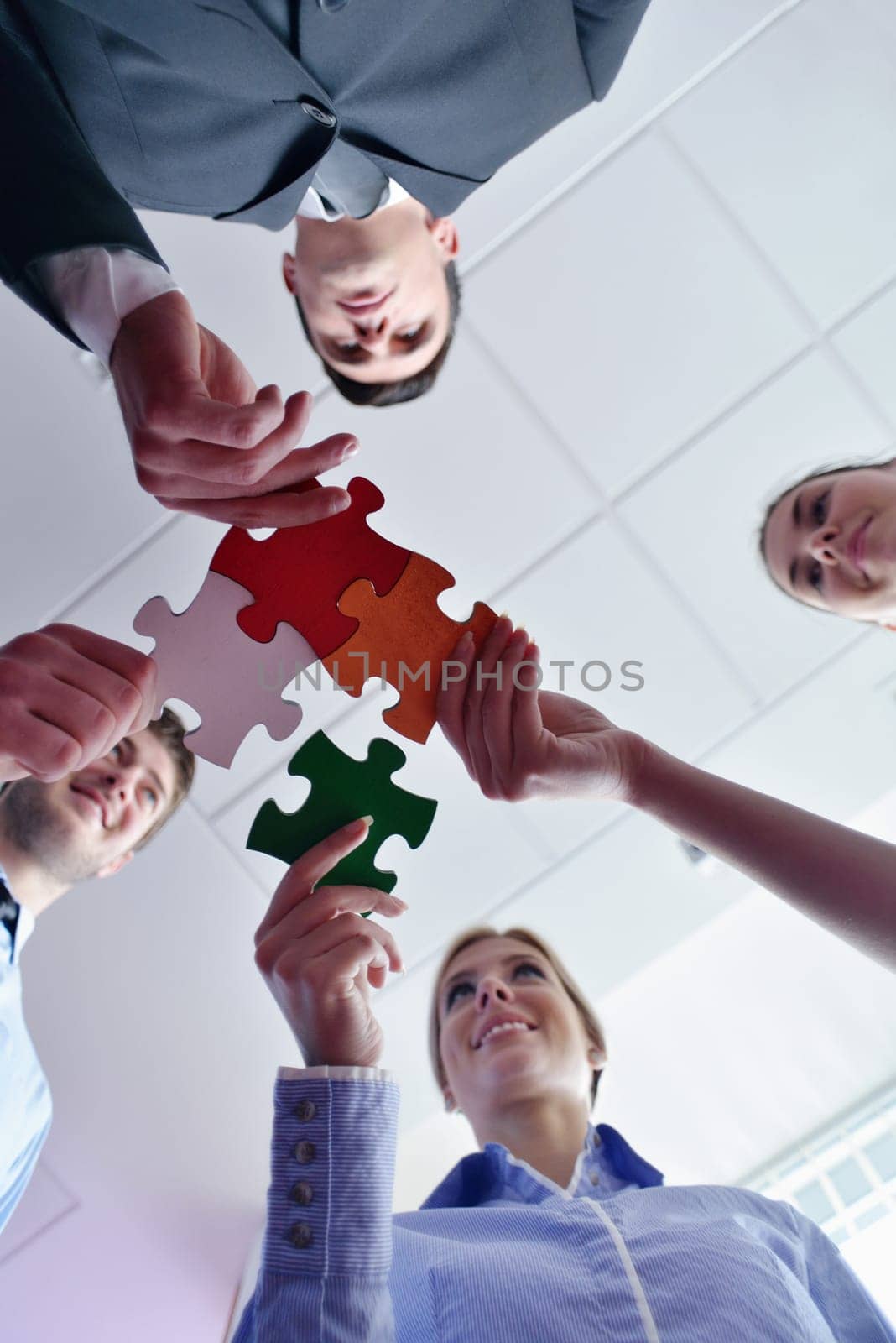 Group of business people assembling jigsaw puzzle and represent team support and help concept