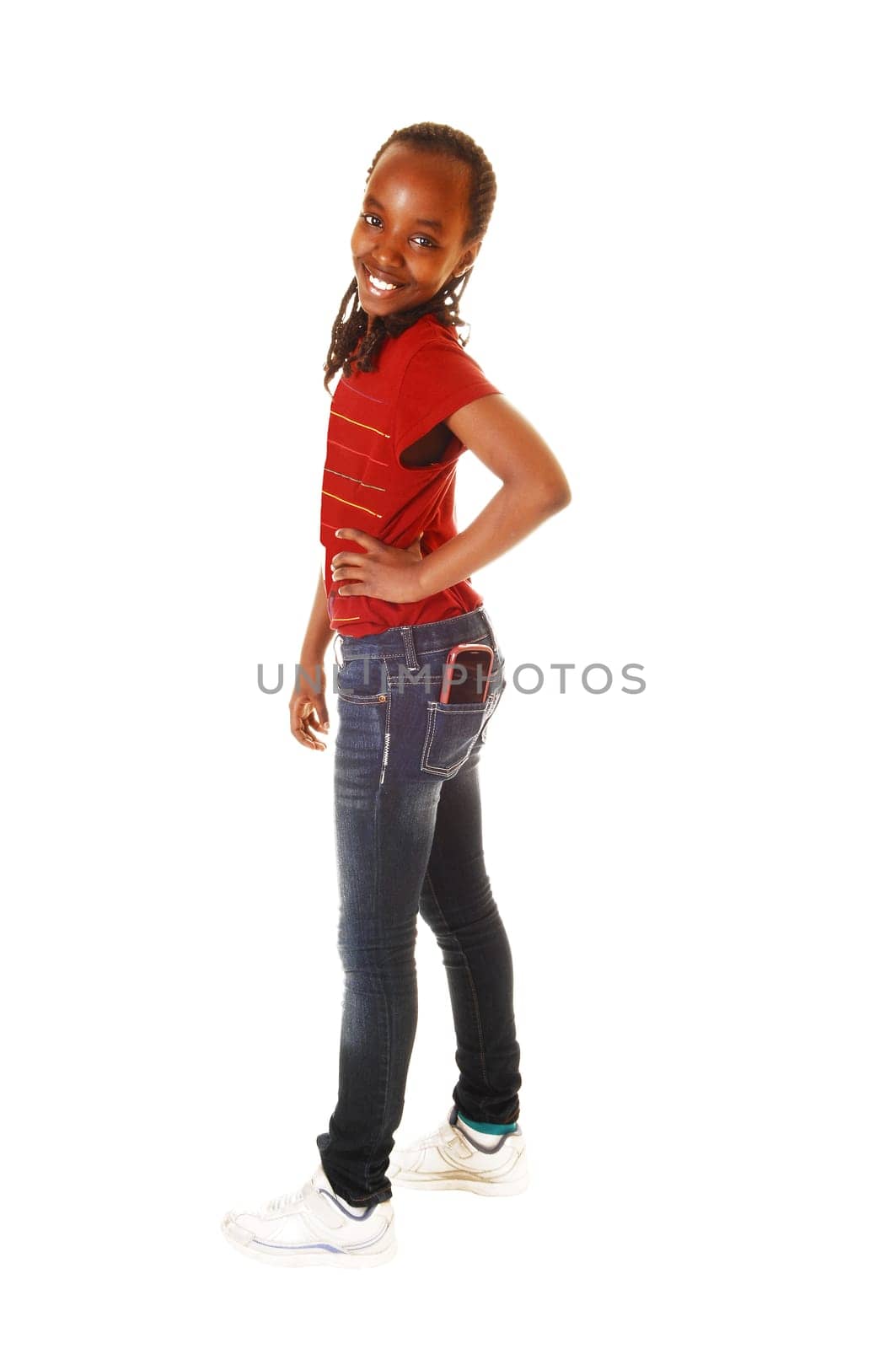 A young lovely teenager girl standing for white background in t-shirt and jeans with her cell phone in her back pocket.