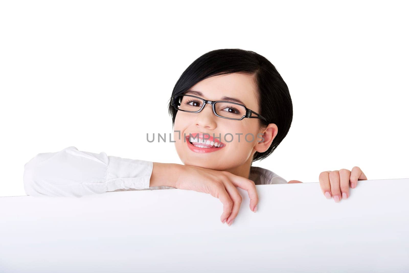 Smiling young business woman showing blank signboard, over white background isolated