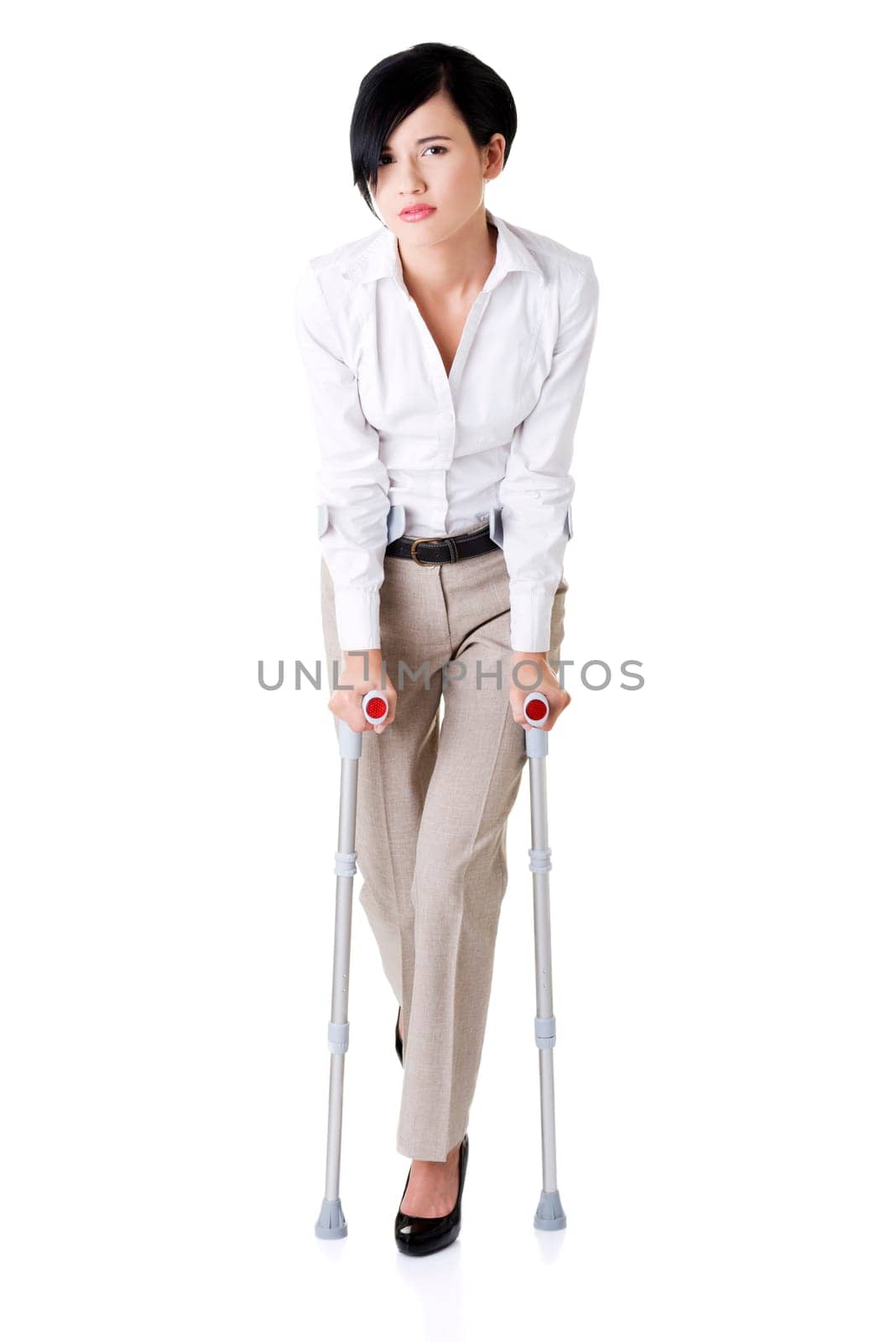 Young businesswoman with crutches, isolated on white. Disabled person in work.