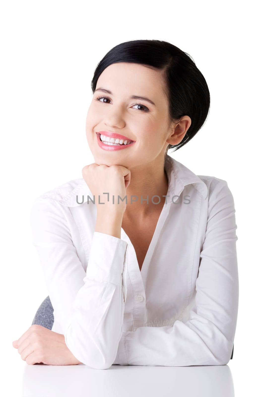 Young beautiful happy businesswoman behind the desk, isolated