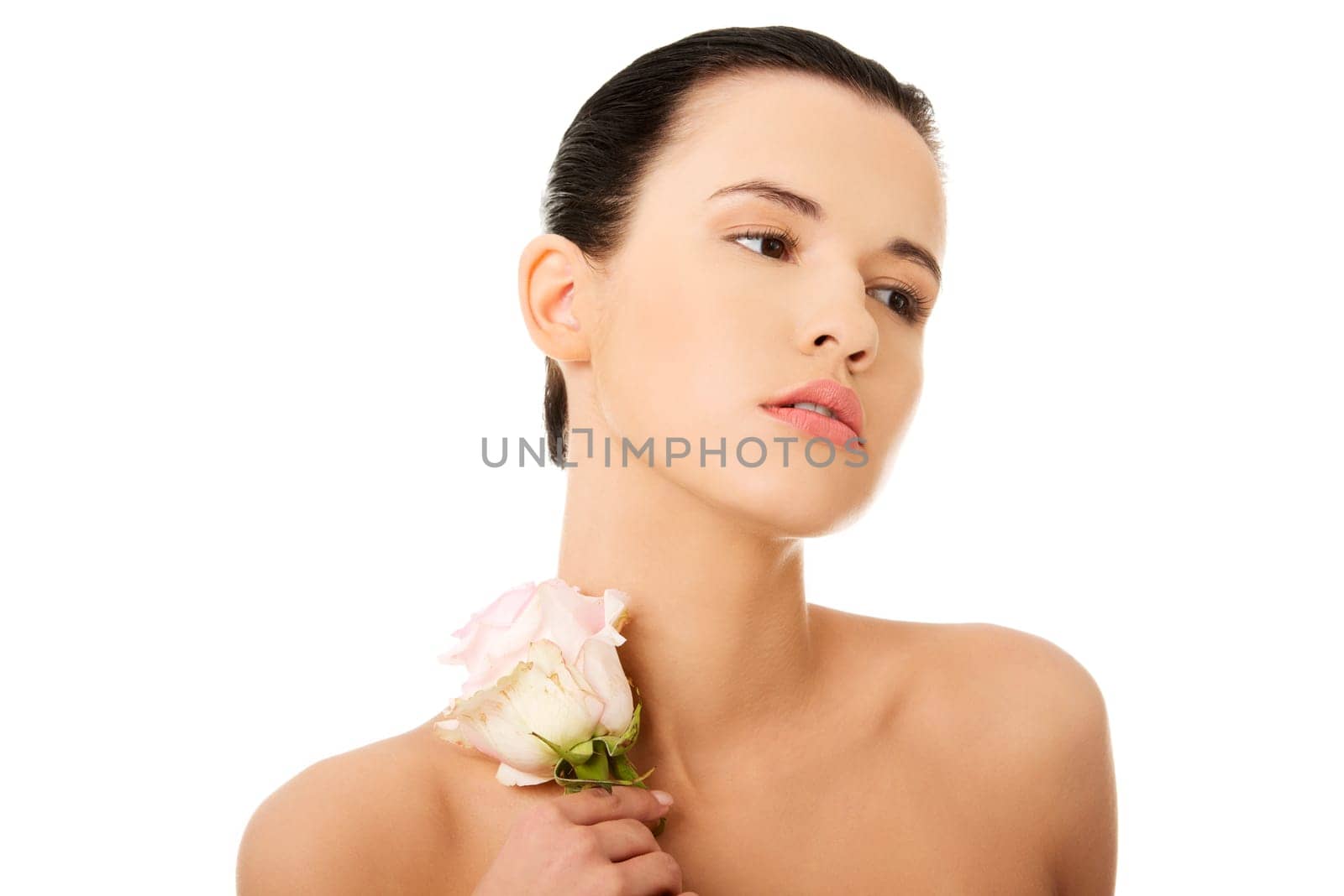 Portrait of beautiful young woman with health skin and with pink rose flower