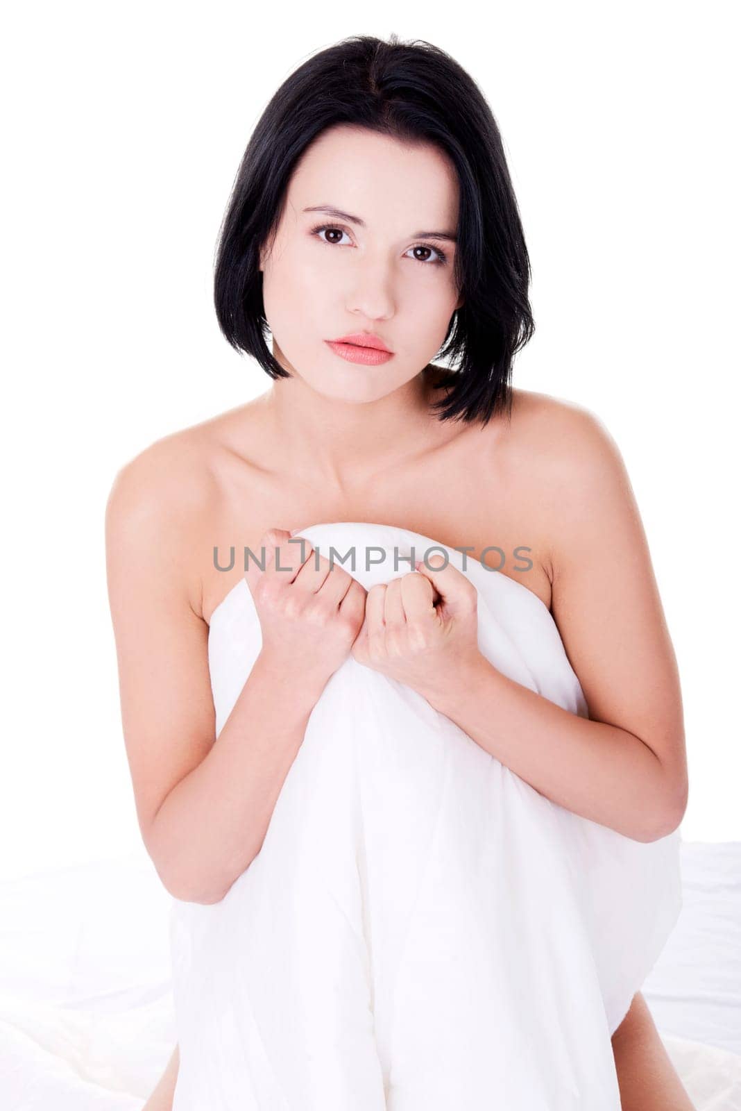 Sexy nude woman covering her body with sheet, isolated in white