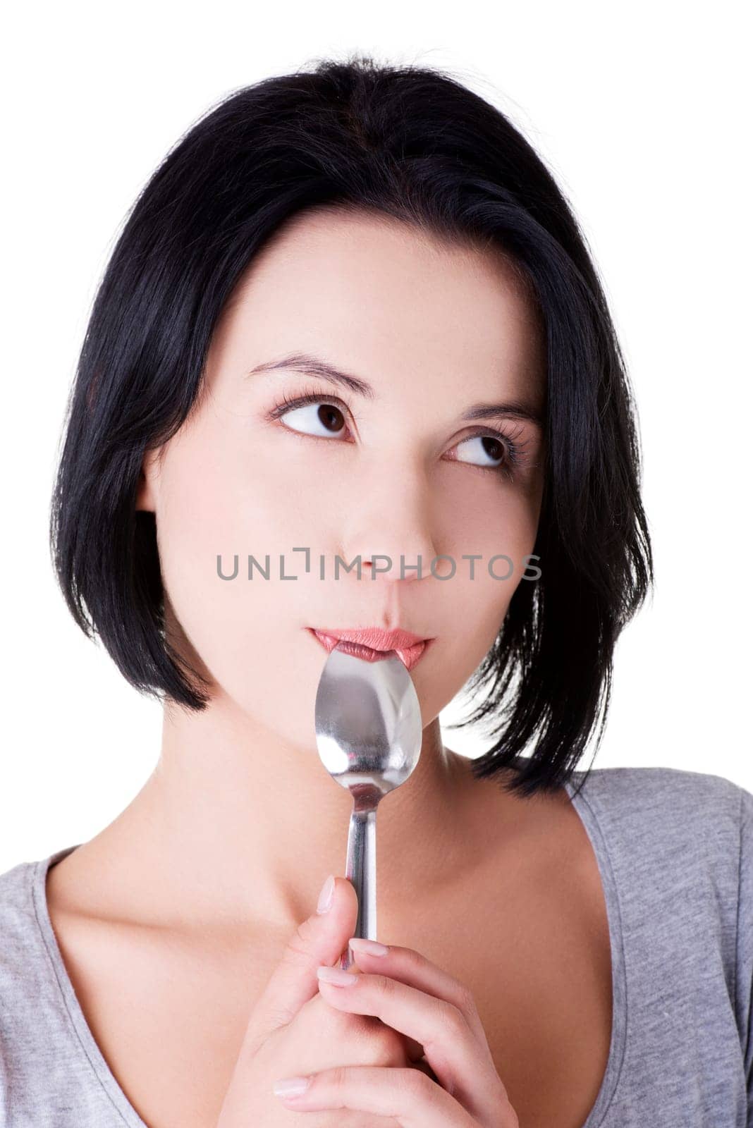 Portrait of young smiling woman with spoon in her mouth (pleasure from eating), isolated on white
