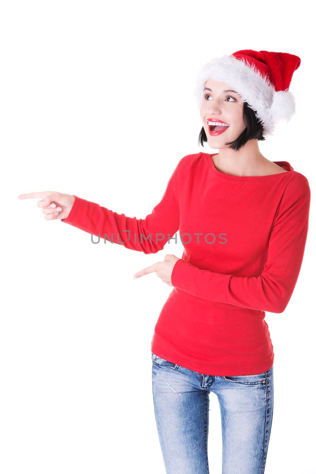 Beautiful smiling christmas santa woman pointing on side showing copyspace. Isolated on white background.