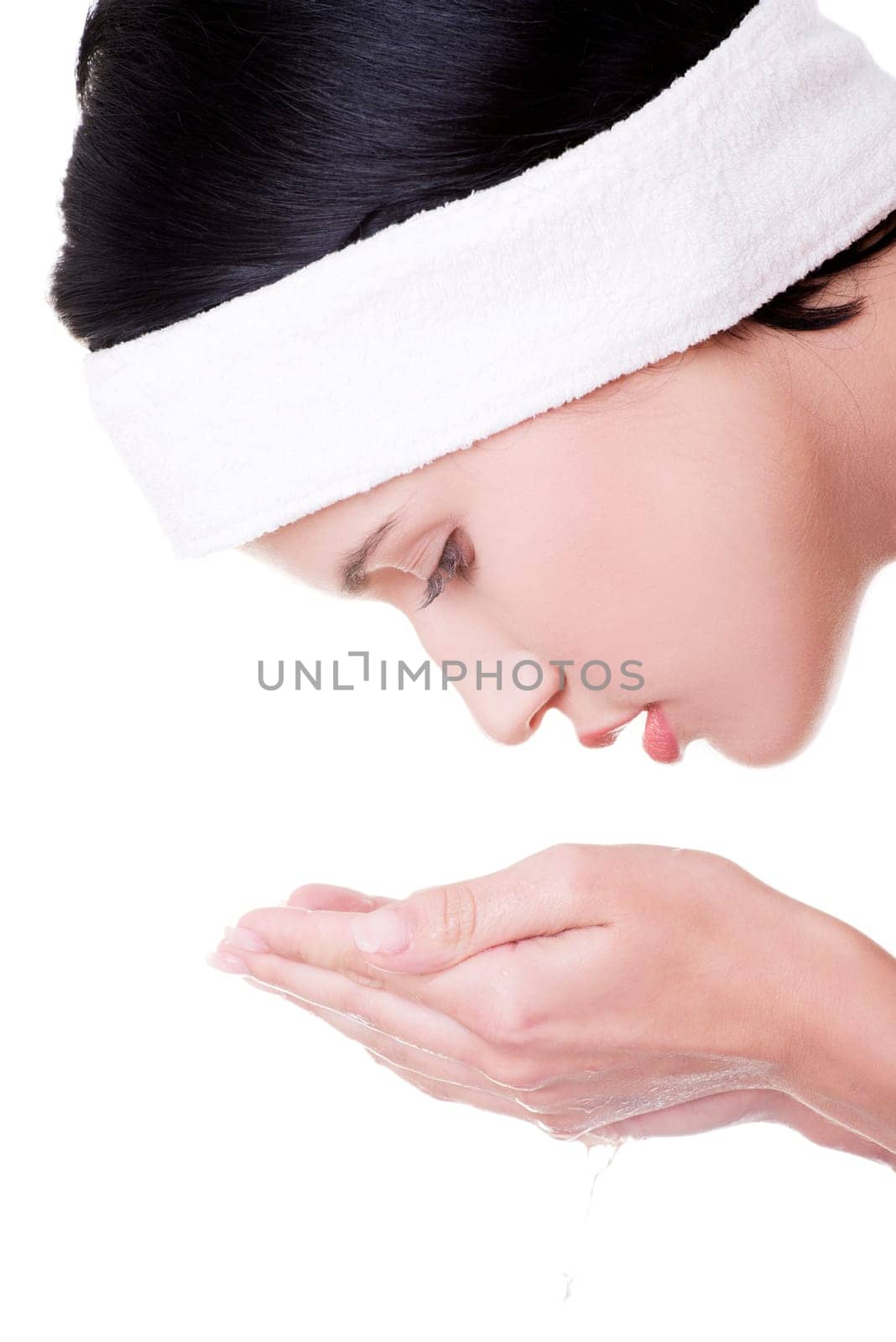 Beautiful brunette woman is cleaning her face , isolated on white