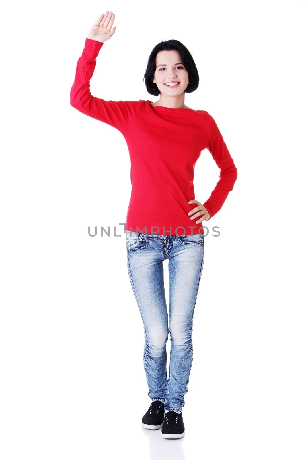 Happy teenage girl waving a greeting , isolated on white
