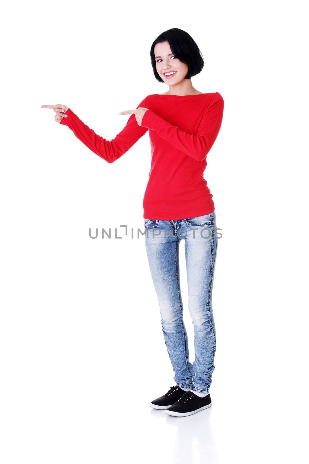 Happy , excited young woman pointing on copy space, isolated on white