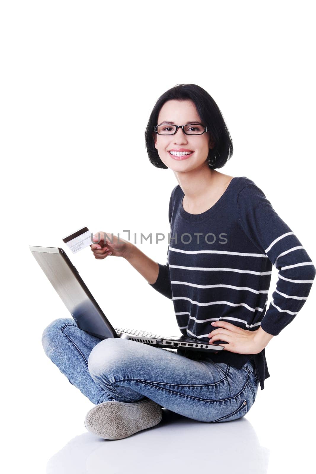 Woman with a laptop and a credit card, sitting on the floor, isolated on white